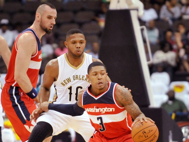 Washington Wizards guard Bradley Beal (3) cuts in front of New Orleans Pelicans guard Eric Gordon (10) during an NBA preseason game Wednesday, October 8, 2014 at Veterans Memorial Arena in Jacksonville.