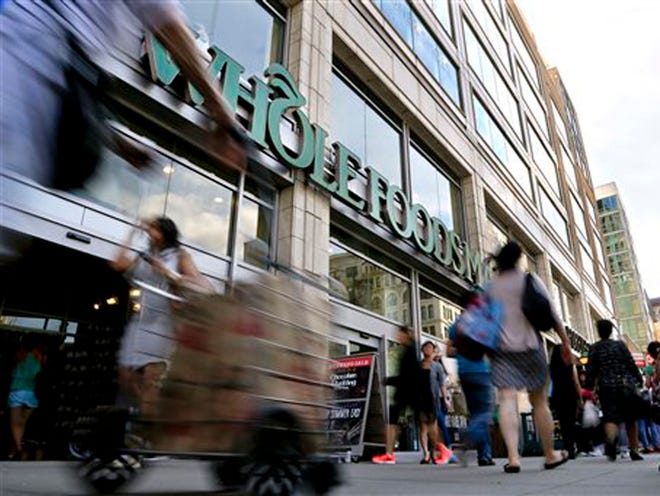 Pedestrians pass in front of a Whole Foods Market store in Union Square, Wednesday, June 24, 2015, in New York. New York City's consumer chief said Wednesday that Whole Foods supermarkets have been routinely overcharging customers by overstating the weight of prepackaged meat, dairy and baked goods.