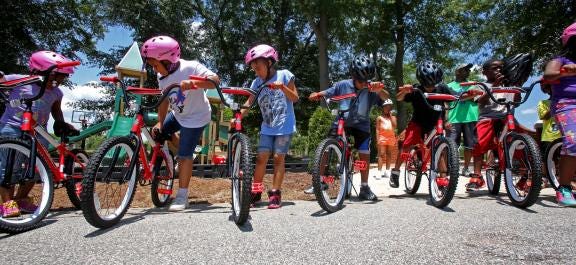 Brittany Randolph/The StarBoys and Girls Club kids prepare to participate in a bicycle rodeo on Monday. Fifty lucky Boys and Girls Club kids will receive bikes and helmets after a drawing. The donation will be given by UnitedHealthCare.