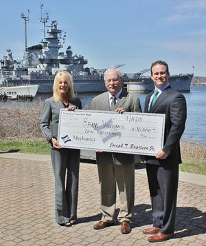 Mechanics Cooperative Bank Executive Vice President Deborah A. Grimes, Saint Vincent's CEO John T. Weldon and Mechanics President and CEO Joseph T. Baptista Jr. gather in front of the USS Massachusetts, where a summer party will be held this weekend. SUBMITTED