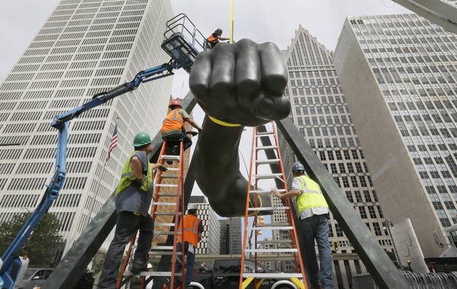 Work crews replace the cables holding Detroit's iconic sculpture of the arm and fist of famed boxer Joe Louis, Wednesday, June 24, 2015, in Detroit. The Detroit Institute of Arts conservation staff will lead a project to replace hanging cables, perform minor structural work and clean the surface of the "Monument to Joe Louis." (AP Photo/Carlos Osorio)
