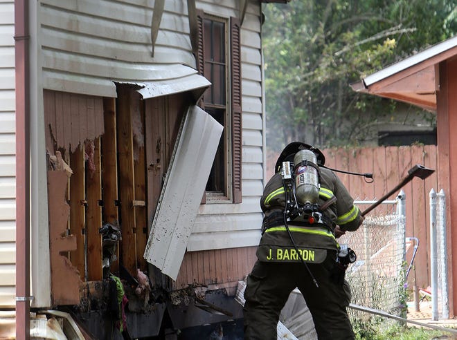 Justin Barron, with Bay County Fire Rescue, checks for hot spots after a fire at a Panama City Beach home on June 24.