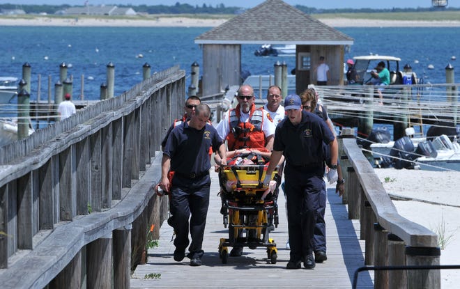 Hyannis firefighters wheel a 17-year-old male down the Hyannisport Yacht Club pier after a boat rescue at the end of the Hyannisport breakwater to rescue the youth who had injured his knee on the rocks. Steve Heaslip/Cape Cod Times
