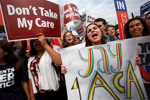 Jessica Ellis (right) holds a sign that says "yay 4 ACA" as she and other supporters of the Affordable Care Act react with cheers as today's ruling is reported outside the Supreme Court in Washington.