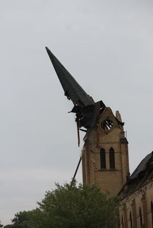 The iconic steeple of the First Baptist Church comes tumbling down on Thursday after Monday's EF1 tornado damaged it beyond repair.