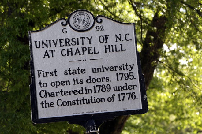 In this photo taken Monday, April 20, 2015 a historical marker erected on Franklin Street provides some informational significance on campus at The University of North Carolina in Chapel Hill, N.C. (AP Photo/Gerry Broome)
