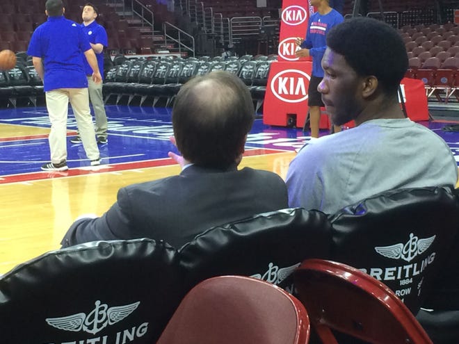 Sixers GM Sam Hinkie chats with injured center Joel Embiid prior to a January game.