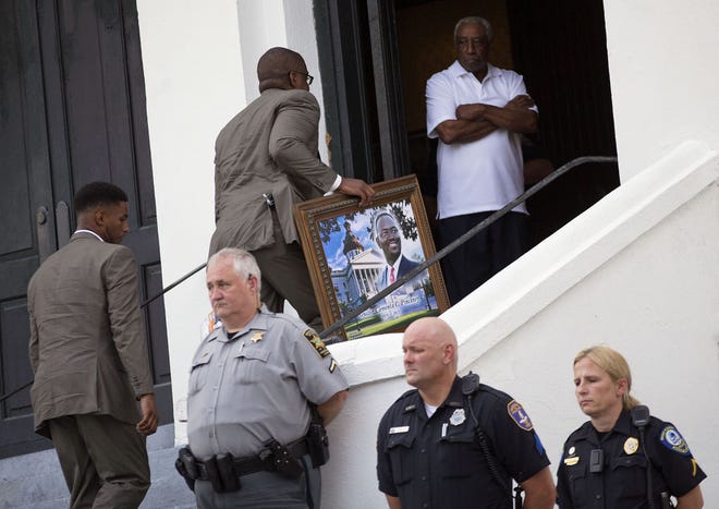 AP Photo/David Goldman A portrait of Sen. Clementa Pinckney, one of the nine killed in last week's shooting, is carried in for his wake at Emanuel AME Church, Thursday, June 25, 2015, in Charleston, S.C. The first funerals of some of those slain began Thursday at nearby churches with a viewing for Pinckney inside Emanuel on Thursday evening. President Barack Obama will deliver the eulogy at Pinckney's funeral Friday at a nearby college arena.
