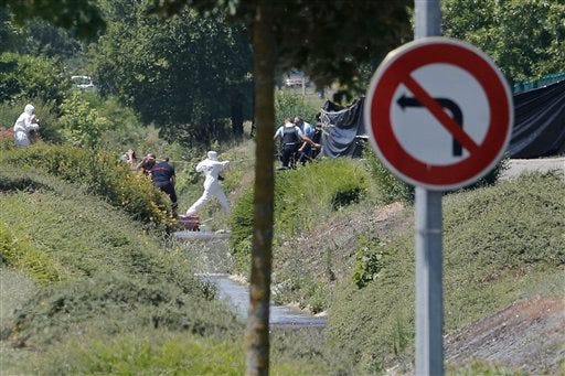 Investigating police officers work outside the plant where an attack took place today in Saint-Quentin-Fallavier, southeast of Lyon, France. (AP Photo / Laurent Cipriani)