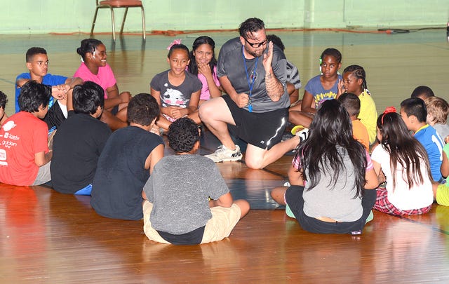BRIAN D. SANDERFORD • TIMES RECORD Wrestling coach Robert Moore teaches basic wrestling moves to children at the Lincoln Youth Service Center, 1422 N. 8th Street, on Thursday, June 25, 2015. Moore said that during the two-day “Camp Success” children learned self respect, discipline and manners through wrestling.