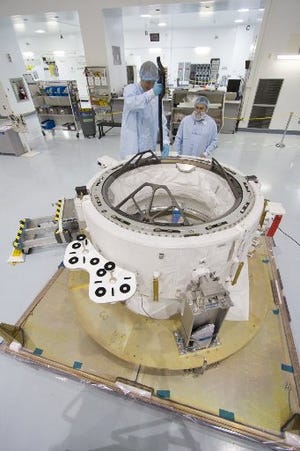 Engineers in the Space Station Processing Facility at the Kennedy Space Center in Cape Canaveral, Fla. check measurements on the International Docking Adapter in March 2015.