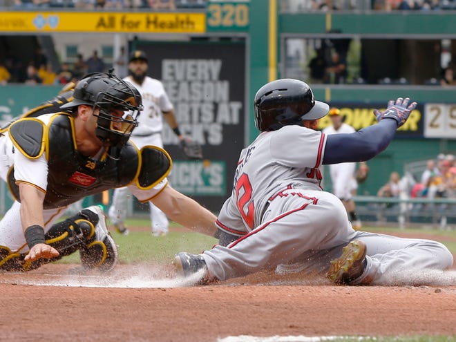 Pittsburgh Pirates catcher Francisco Cervelli tags out Atlanta’s Nick 
Markakis as he tries to score during Saturday’s game in Pittsburgh.