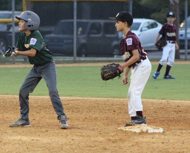 WILL.BROWN@STAUGUSTINE.COM Yulee's Brent Smith, right, dances off second base during the second inning of a 9/10 All-Stars baseball game at the St. Augustine Little League complex on Thursday June 25, 2015. St. Augustine's Nathan Lease is standing on the bag hoping for a chance to tag out Smith. St. Augustine won 31-28 to advance to the tournament semifinals.