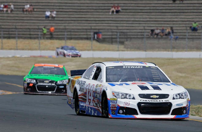 Tony Stewart, right, followed by Danica Patrick, left, competes during qualifying for the NASCAR Sprint Cup Series auto race Saturday, June 27, 2015, in Sonoma, Calif. (AP Photo/Eric Risberg)