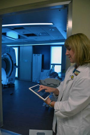 DeeAnna Wilkerson/Bluffton Today    Jane Ouimette, director of imaging services at Coastal Carolina Hospital, demonstrates how to change the color of the new MRI room with an iPad.