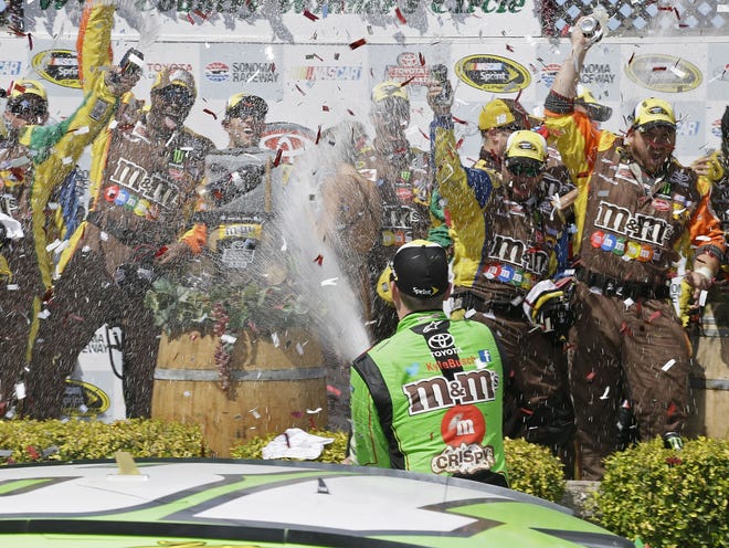 Kyle Busch sprays his crew after winning the NASCAR Sprint Cup Series race Sunday in Sonoma, California.