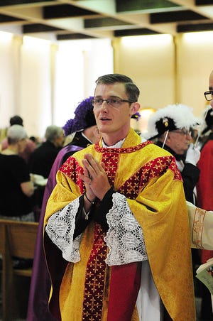 Father David Rombold, leaves the sanctuary after Mass at his home parish of Holy Redeemer, Ellwood City. The Rev. David George Rombold Jr. was ordained Saturday as a priest, the first member of Holy Redeemer Catholic Church in Ellwood City to be ordained since the parish was formed in February 2000.