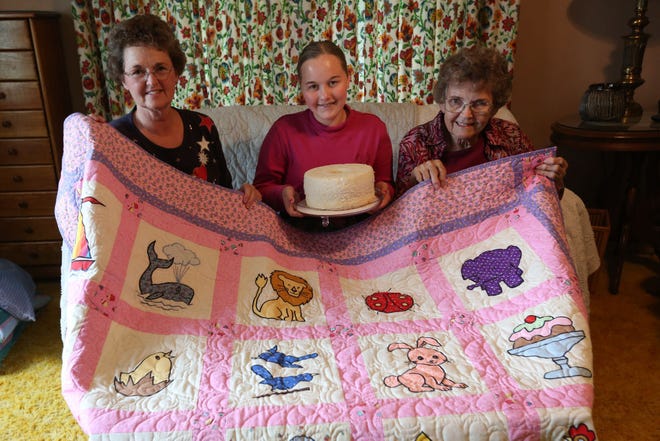 Susan Young, Ava Tatro and Nancy Young pose with a quilt and a cake Thursday, June 18, 2015. The family has a tradition of entering the county and state fairs that reach back 70 years.