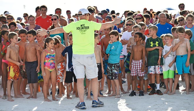 Manasota Track Club Race announcer Dan Pollock lines up the young runners for one of the 2015 summer runs at Siesta Key Beach.