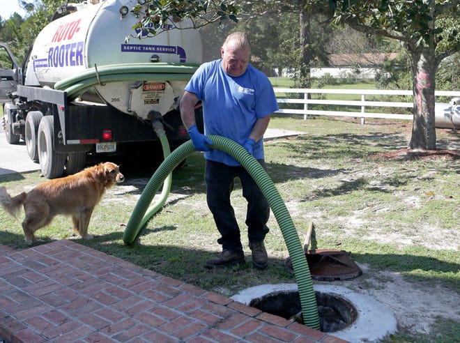 Jay Nazarijchuk empties a septic tank with Roto-Rooter in October 2014 in Southport. Under a proposed county law, Southport residents would be required to either hook into the county’s centralized water and sewer service or pay a monthly $22.60 “availability charge” for living in close proximity to the utility lines.