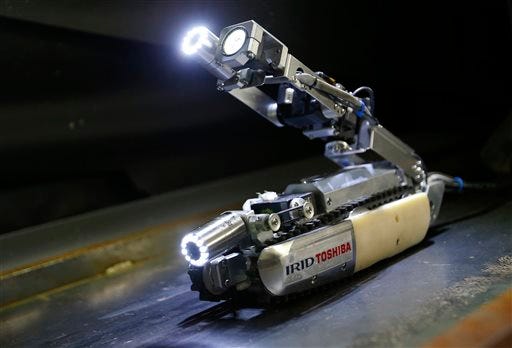 A robot developed by Toshiba Corp. is demonstrated at its laboratory in Yokohama, near Tokyo, Tuesday, June 30, 2015. As Japan struggles in the early stages of decades-long cleanup of the Fukushima nuclear crisis, Toshiba has developed the robot that raises its tail like a scorpion and collects data, and hopefully locate some of melted debris. The "scorpion" robot, which is 54 centimeters (21 inches) long when extended, has two cameras, LED lighting and a dosimeter, will be sent into the Unit 2 reactor in August to look. (AP Photo/Shizuo Kambayashi)