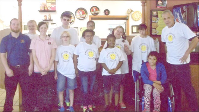 Happy Joe’s manager Bob Plum posed with this group of special-needs kids who visited the restaurant when bad weather forced cancellation of their planned trip to Camp Big Sky.