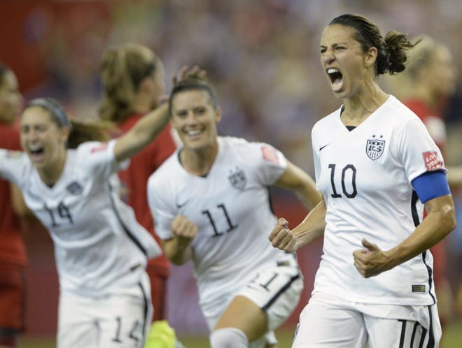 United States' Carli Lloyd celebrates with teammates Ali Krieger (11) and Morgan Brian after scoring on a penalty kick against Germany during the second half of Tuesday's Women's World Cup soccer game in Montreal, Canada. Ryan Remiorz/The Canadian Press via The Associated Press