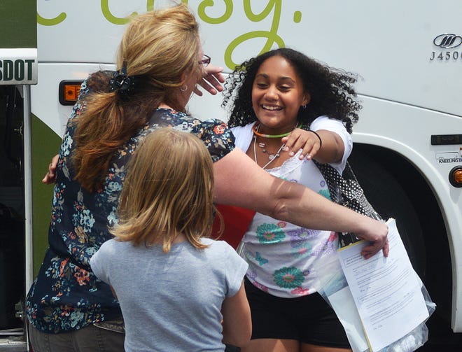 Aaliyah Cabrera, 11, from Manhattan. runs off the bus to hug Sharon Passaretti, with whom she will be staying as part of the Fresh Air Fund program.
