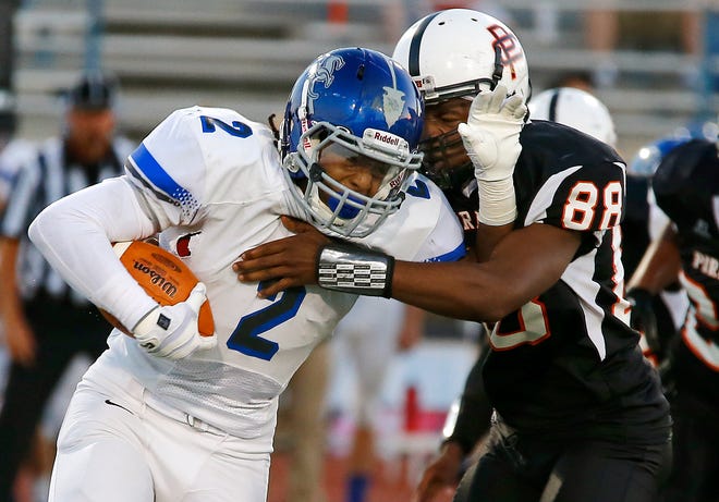 Sapulpa's Dae Williams fights off Putnam City's Vernon Bills during their high school football game at Putnam City in Oklahoma City, Thursday, Sept. 26, 2013. Photo by Bryan Terry, The Oklahoman