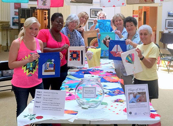 The Twin Rivers Quilting Guild join the Craven Arts Council and representatives of the Coastal Women’s Shelter for a ‘flag bee’ at the Bank of the Arts.