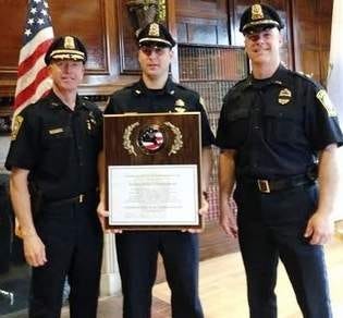 In a June 2014 file photo, Police Chief Allen Krajcik, left, and Lt. Gary Sullivan, right, accept an award for the police department's re-accreditation along with Sgt. Keith Boone, center.