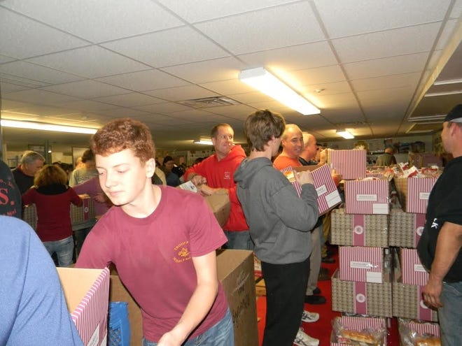 Volunteers help fill Thanksgiving baskets at the Sacred Heart Food Pantry in Middleboro in 2014. July 2, 2015.