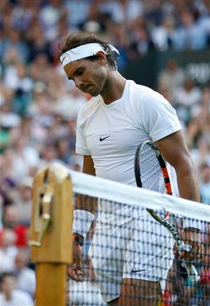 Rafael Nadal walks off the court after losing his singles match against Dustin Brown at Wimbledon Thursday. AP photo