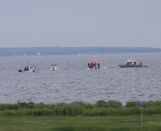 Searchers in boats look for a man who went swimming from his boat near the Rhode Island Country Club. The man's boat is the second from left. Photo taken from Nayatt Road near Middle Highway. The Providence Journal/Mary Murphy