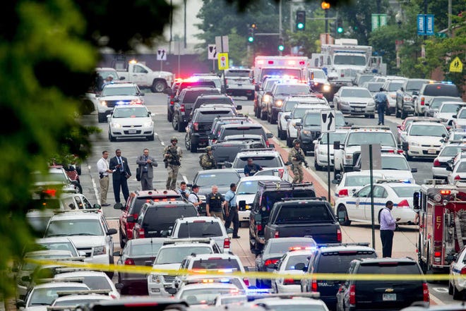 A large police presence gathers along M St. Southeast near the Navy Yard in Washington, Thursday, July 2, 2015, after an official said shots were reported in a building on the Washington Navy yard campus.