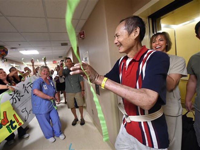 She Yan Chen gets a surprise greeting at Regions Hospital in St. Paul, Minn., when he gets out of an elevator after physical therapy on Thursday, July 2, 2015. Chen, who survived being badly burned in a lawnmower explosion was discharged Friday, July 3 after 264 days in Regions Hospital, but not before his caregivers gathered to say farewell to one of their favorite patients.