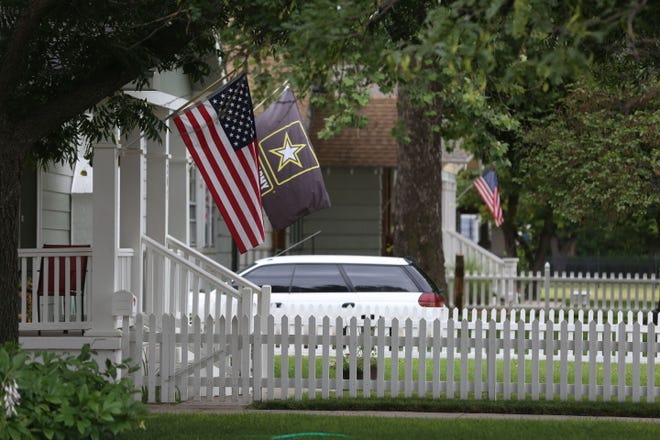 U.S. flags hang from the front porches of houses on East 19th Avenue on Wednesday.