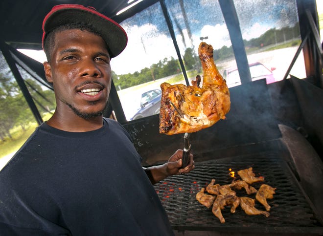 Shawn Henderson shows off smoked chicken on June 26 at his Silver Springs Shores roadside stand.