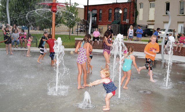 CHAD HUNTER TIMES RECORD    Children play in the new splash pad at Compass Park in downtown Fort Smith late Thursday, July 2, 2015.