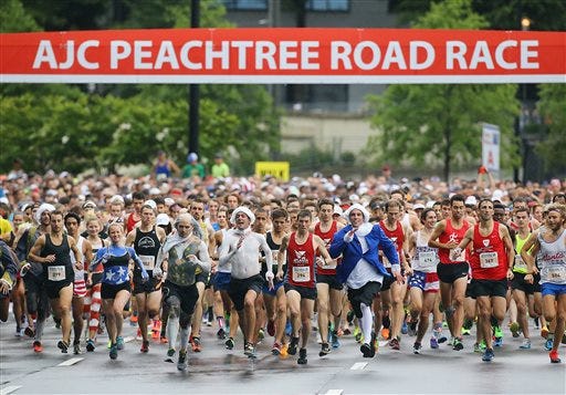 The main group, with Benjamin Franklin, Thomas Jefferson, and George Washington characters at the front of the pack is off and running to start the AJC Peachtree Road Race on Saturday, July 4, 2015, in Atlanta. (Curtis Compton/Atlanta Journal-Constitution via AP)