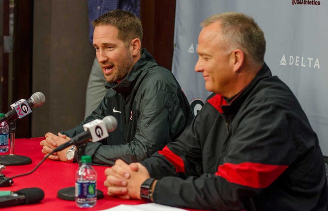 Georgia offensive coordinator Brian Schottenheimer nods his head toward head coach Mark Richt while answering a question during a press conference at Butts-Mehre Heritage Hall in Athens, Ga., on Friday, Jan. 9, 2015.