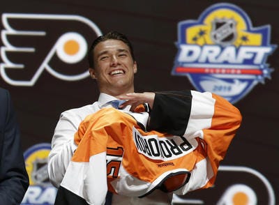 Ivan Provorov, of Russia, puts on a Philadelphia Flyers sweater after being chosen seventh overall during the first round of the NHL hockey draft, Friday, June 26, 2015, in Sunrise, Fla. (AP Photo/Alan Diaz)