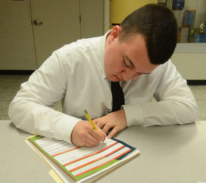 Justin Keller, 16, a student at Cherokee High School, fills out a job application for Chick Fil-A in Evesham during the Lenape Regional High School District's 4th Annual Student Job Fair held Wednesday, March 18, 2015 at Lenape High School in Medford.