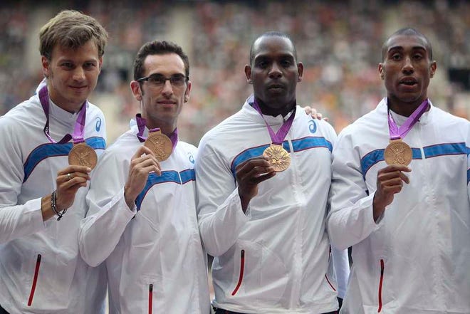 France relay team from left, Christophe Lemaitre, Pierre-Alexis Pessonneaux, Ronald Pognon and Jimmy Vicaut pose during a medal ceremony at the Stade de France stadium, in Saint Denis north of Paris, France, Saturday July 4, 2015. Three years late, France's men got their 4x100-meter relay bronze medal from the London Olympics on Saturday, bumped up from fourth after the U.S. team was disqualified because of Tyson Gay's doping. (AP Photo/Thibault Camus)