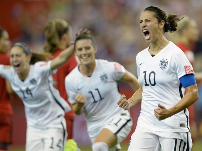 United States' Carli Lloyd (10) celebrates with teammates Ali Krieger (11) and Morgan Brian after scoring on a penalty kick against Germany during the second half of a semifinal in the Women's World Cup. The United States plays Japan on Sunday for the title.