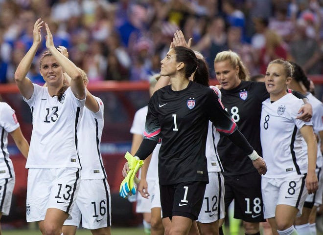 United States' Alex Morgan (13) and goalkeeper Hope Solo (1) salute the crowd after the U.S. team defeated Germany 2-0 in a semifinal in the Women's World Cup soccer tournament, Tuesday, June 30, 2015, in Montreal, Canada.