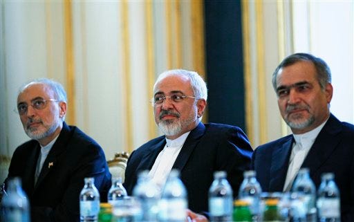 Iranian Foreign Minister Mohammad Javad Zarif, centre, Head of the Iranian Atomic Energy Organization Ali Akbar Salehi, left, and Hossein Fereydoon, brother and close aide to President Hassan Rouhani, meet with U.S. Secretary of State John Kerry in Vienna, Austria, Friday July 3, 2015. Iran has committed to implementing the IAEA's "additional protocol" for inspections and monitoring as part of an accord, but the rules don't guarantee international monitors can enter any facility including sensitive military sites, so making it difficult to investigate allegations of secret work on nuclear weapons. (Carlos Barria/Pool via AP)