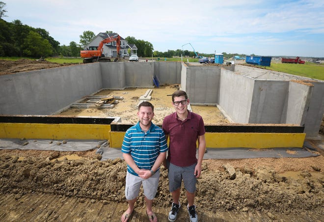 Ryan Cook and Trent Kasper stand in front of the foundation of their 4,500 square foot home being built in Minnestrista, Minn. They say low interest rates make the project possible. PHOTO BY RENEE JONES SCHNEIDER/MINNEAPOLIS STAR TRIBUNE/TNS