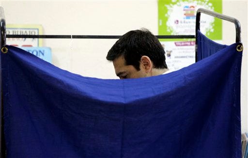 Greece's Prime Minister Alexis Tsipras casts his vote at a polling station in Athens, Sunday, July 5, 2015. Greeks began voting early Sunday in a closely-watched, closely-contested referendum, which the government pits as a choice over whether to defy the country's creditors and push for better repayment terms or essentially accept their terms, but which the opposition and many of the creditors paint as a choice between staying in the euro or leaving it. (AP Photo/Petros Giannakouris)