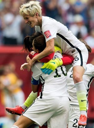 United States goalkeeper Hope Solo, back left, and Megan Rapinoe, top, celebrate with Carli Lloyd (10) after Lloyd's third goal against Japan during the first half of the FIFA Women's World Cup soccer championship in Vancouver, British Columbia, Canada, on Sunday, July 5, 2015.